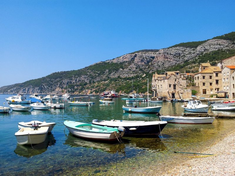 Boats moored in bay of Beautiful old island town of Komiža on Vis island in Croatia.